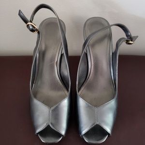 Grey metallic open toe heels.